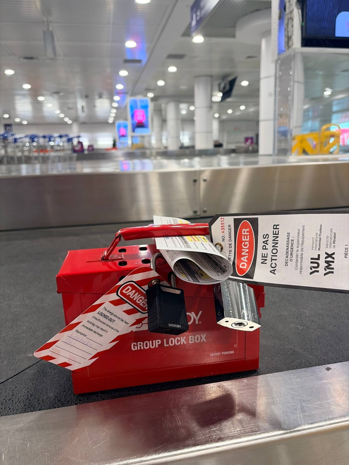 Boîte de cadenassage de groupe et étiquettes dans la zone des carrousels à bagages