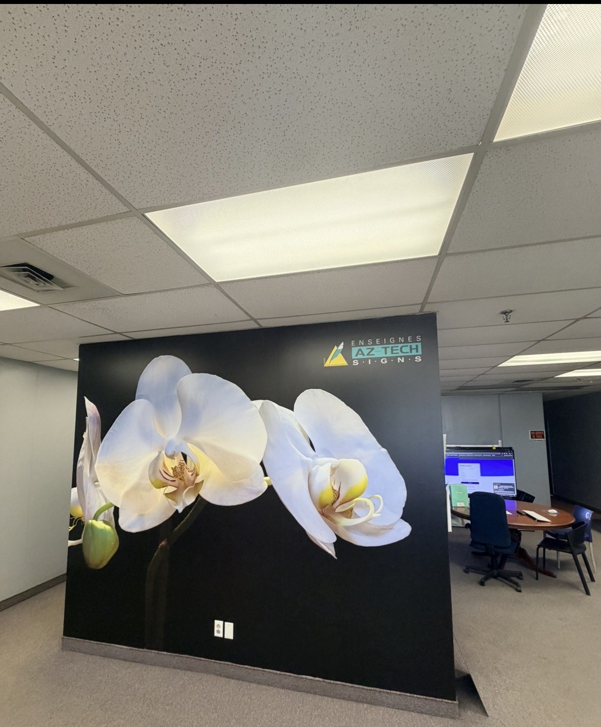 The Az-Tech office with an orchid wall graphic and the company logo