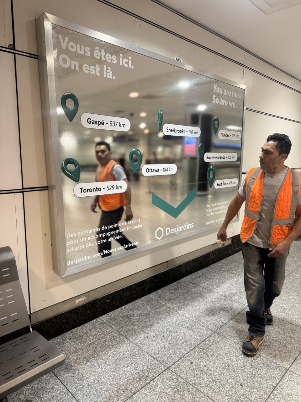 Installation publicitaire Desjardins à effet miroir et membre de l’équipe sur place