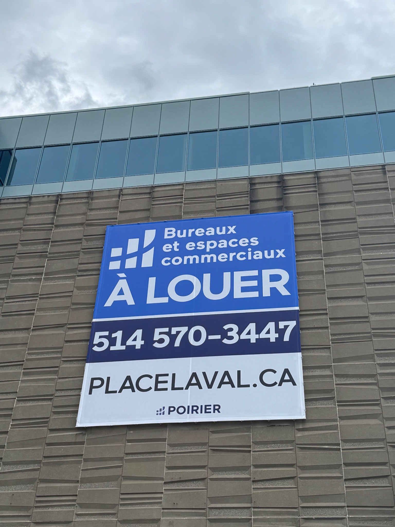 Bannière Place Laval installée sur la façade du bâtiment