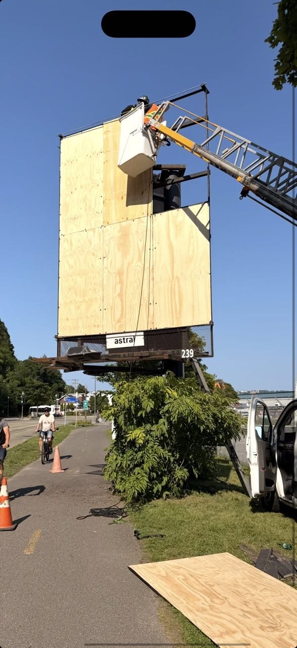 Travaux sur le support en contreplaqué d’un panneau Astral avec une nacelle